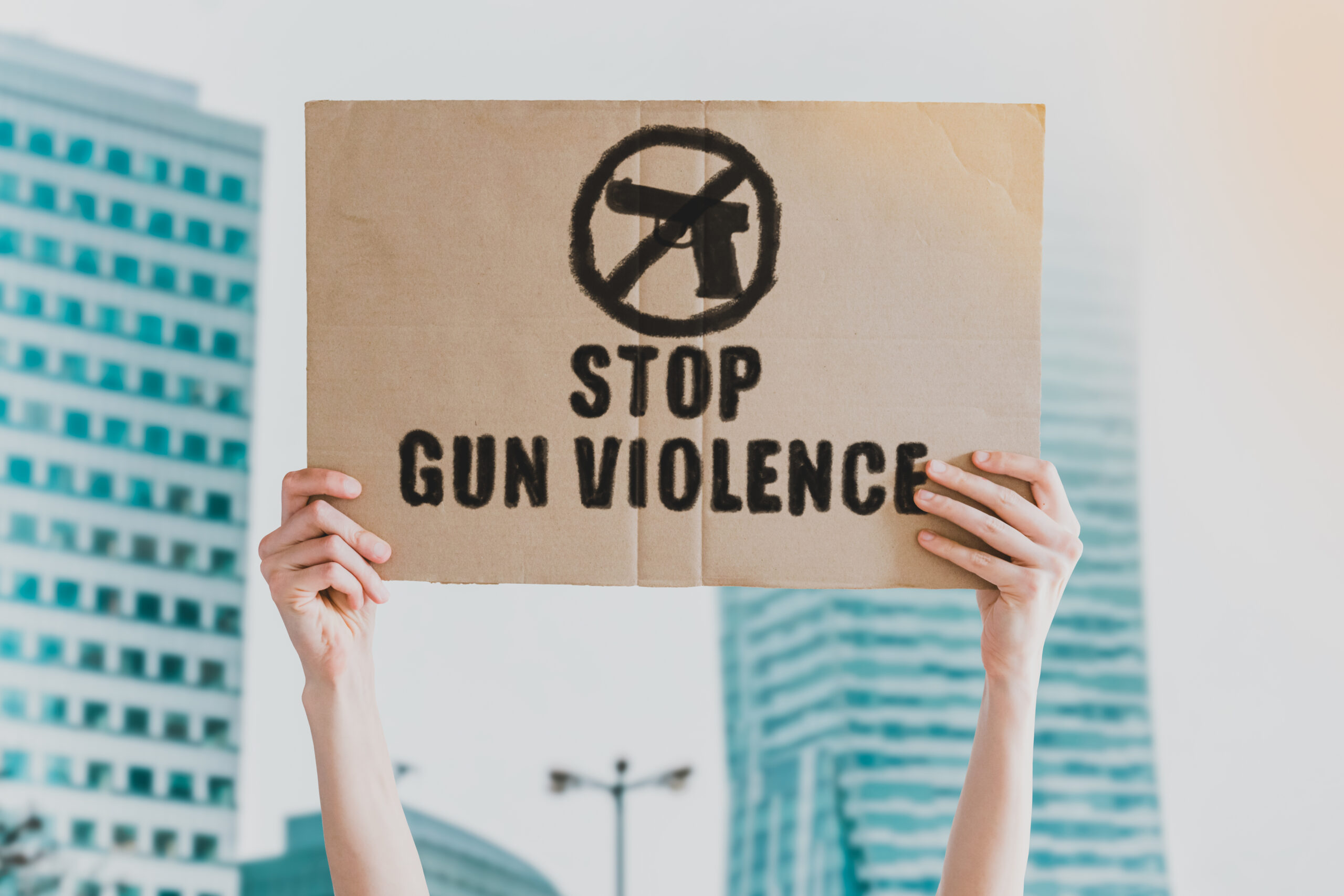 hands holding protest sign that says stop gun violence